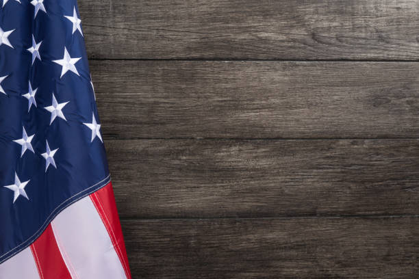 US flag with embossed stars, hanged against old wooden wall background